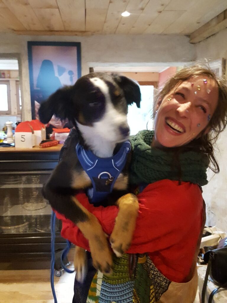jeune femme entrepreneuse qui rit en tenant un chien dans ses bras